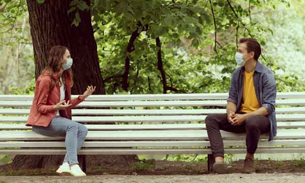 Young couple with masks on park bench could feature in kids historical fiction.