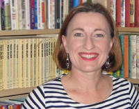 Smiling head and shoulders of Marielle Rebbechi in front of book shelves